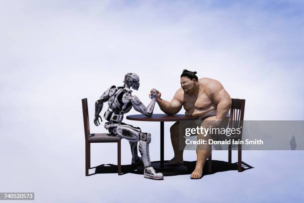 sumo wrestler arm wrestling with robot - duelleren stockfoto's en -beelden