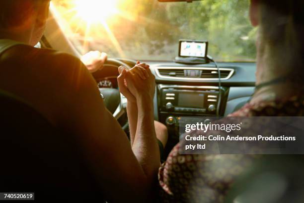 couple driving in sunny car - holding hands in car stock pictures, royalty-free photos & images