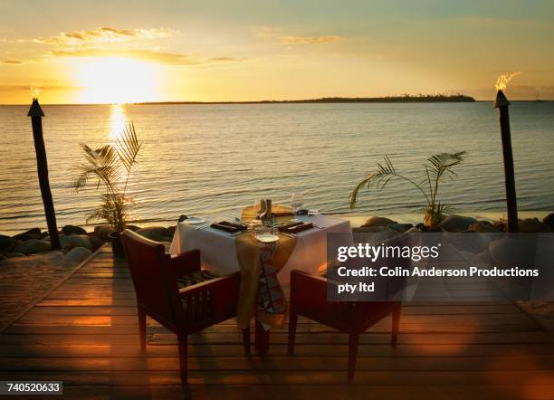 table and chairs on waterfront at sunset - table for two stock pictures, royalty-free photos & images