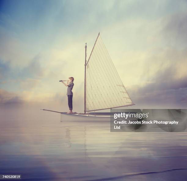 caucasian boy standing on sailboat using telescope - boat melbourne stock-fotos und bilder