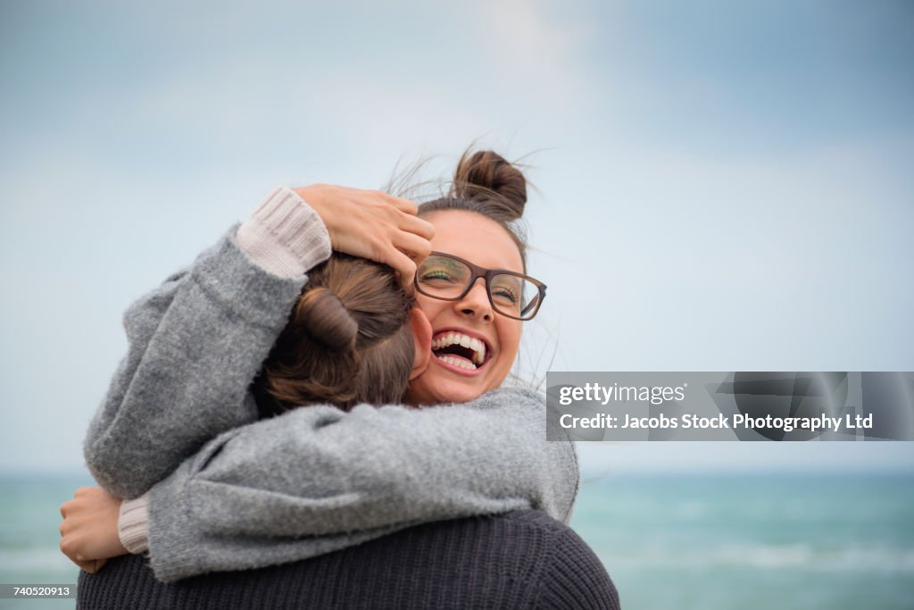 Caucasian couple hugging on beach