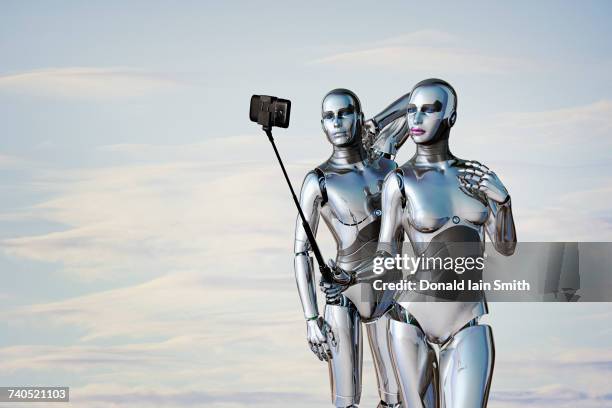 robot couple posing for cell phone selfie - cyborg fotografías e imágenes de stock