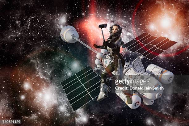 woman astronaut posing for cell phone selfie during space walk - selfiestick stock-fotos und bilder