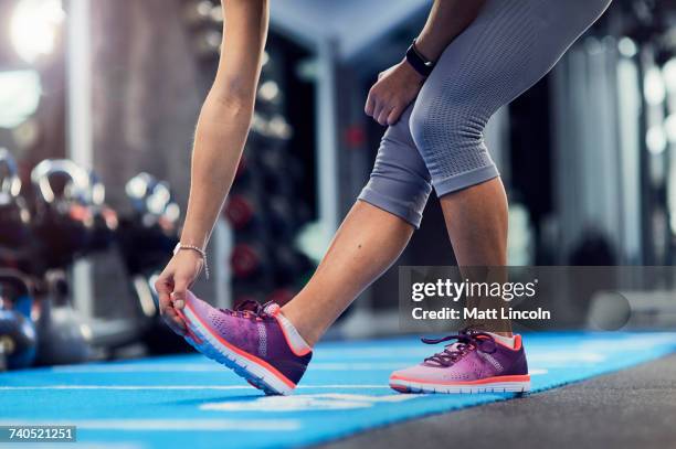 waist down view of young woman touching toes on gym mat - low section woman stock pictures, royalty-free photos & images