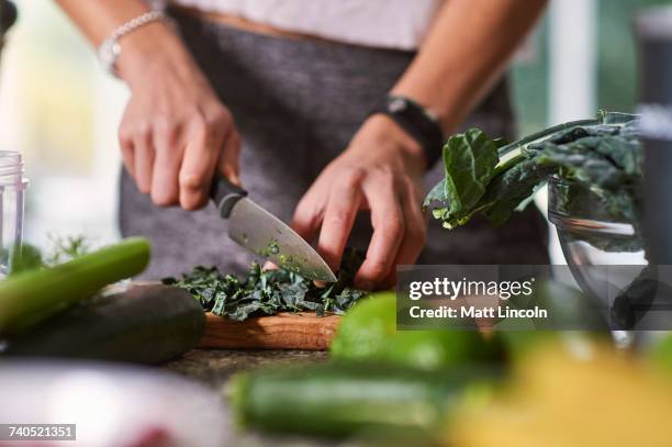 hands of young woman slicing cabbage at kitchen table - knife kitchen stock pictures, royalty-free photos & images