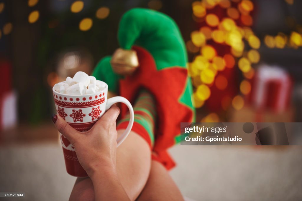 Woman wearing elf slippers holding hot chocolate