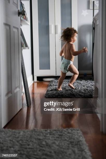 caucasian boy wearing diaper running in corridor - diaper boy fotografías e imágenes de stock
