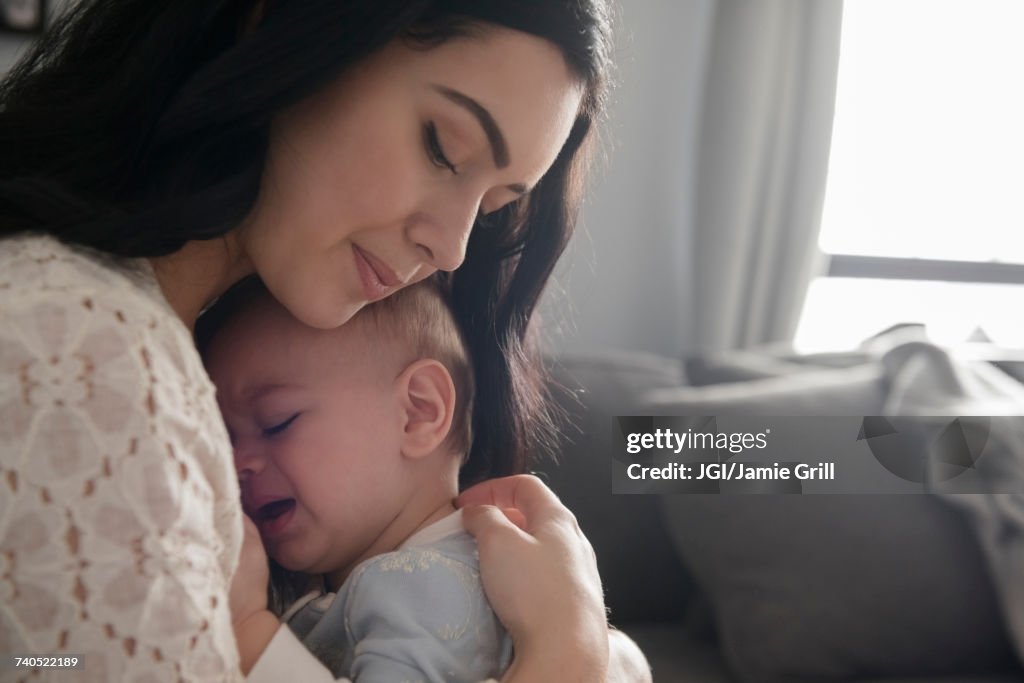 Caucasian mother comforting crying baby son