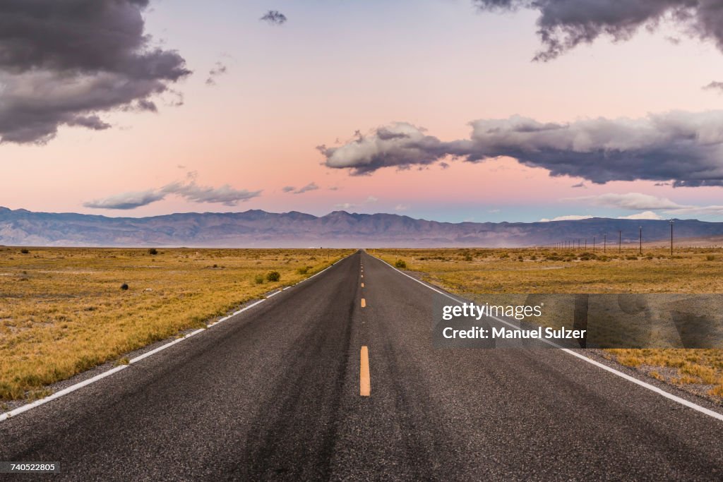 Straight road at sunset in Death Valley National Park, California, USA