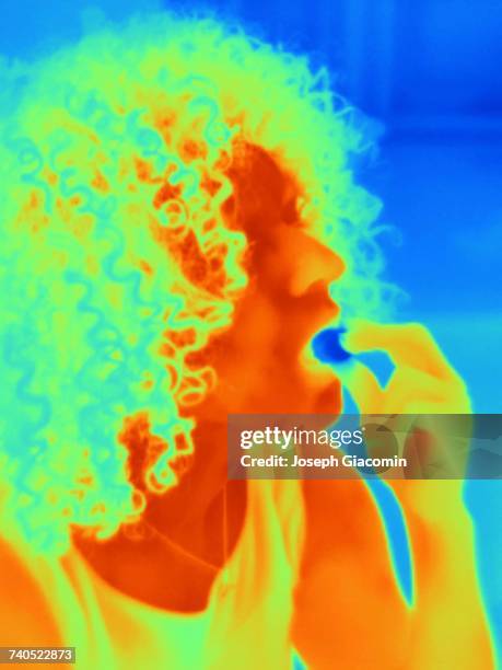 thermal image portrait of mid adult woman eating - 熱映像 ストックフォトと画像