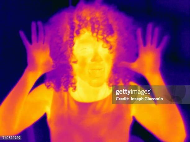 thermal image portrait of mid adult woman with raised hands - harrow london stock pictures, royalty-free photos & images