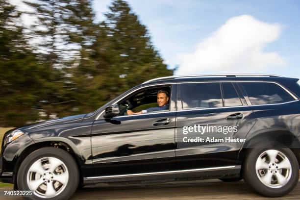 caucasian man driving car - car side by side stock pictures, royalty-free photos & images