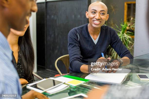 smiling man with notebook in meeting - trana stock pictures, royalty-free photos & images