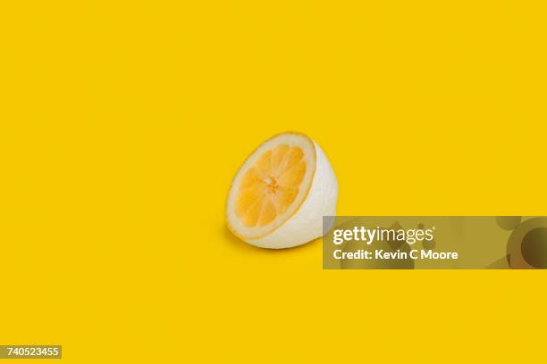 Half a lemon painted white on yellow background