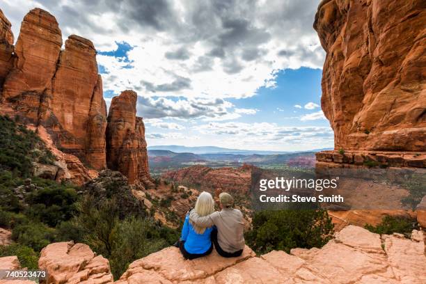 caucasian couple admiring scenic view in desert landscape - old couple adventure stock-fotos und bilder