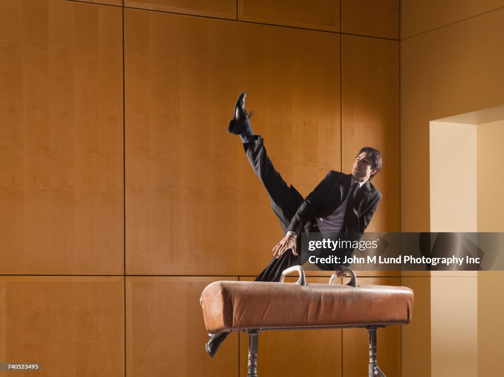 Hispanic businessman using pommel horse