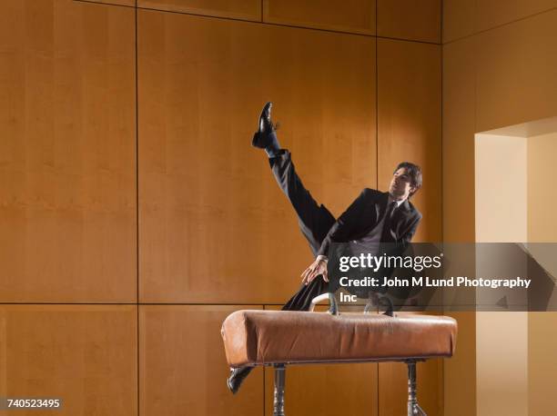 hispanic businessman using pommel horse - pommel horse bildbanksfoton och bilder