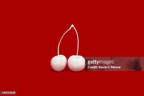 Cherries painted white on red background