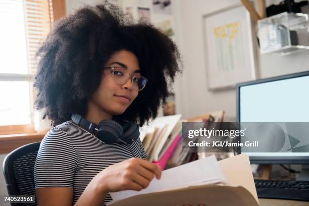 confident african american woman holding files near computer - will files stock pictures, royalty-free photos & images