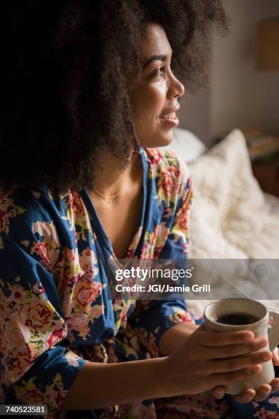 african american woman sitting in bed drinking coffee - robe 2017 stock pictures, royalty-free photos & images