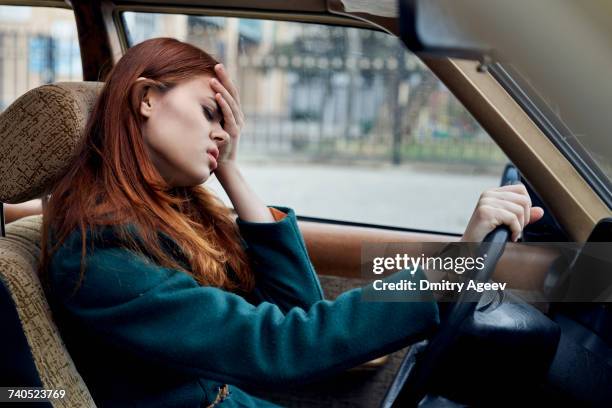 frustrated caucasian woman driving car - covered car stock-fotos und bilder