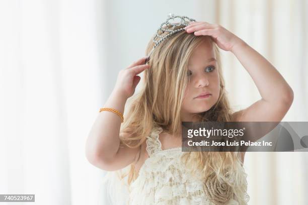 caucasian girl adjusting tiara - kids tiara stock pictures, royalty-free photos & images