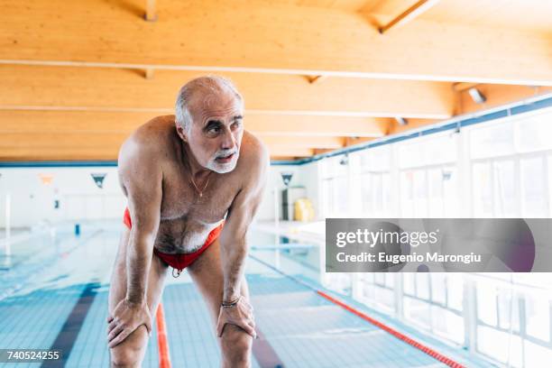 senior man bending over catching his breathe by pool - catching breath stock pictures, royalty-free photos & images