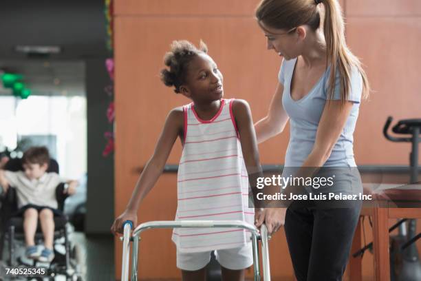 physical therapist helping girl with walker - patient profile stock pictures, royalty-free photos & images