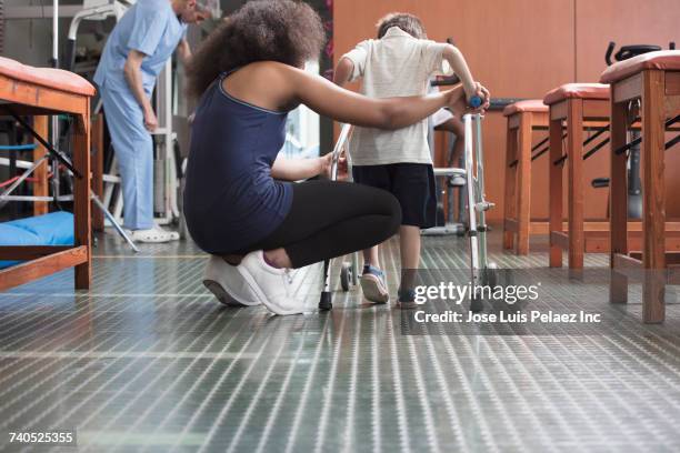 physical therapist helping boy with walker - rehab stock pictures, royalty-free photos & images