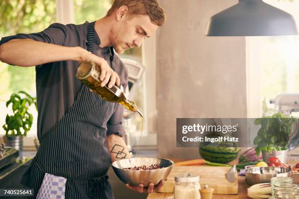 chef drizzling oil on bowl of food - olive oil stock pictures, royalty-free photos & images
