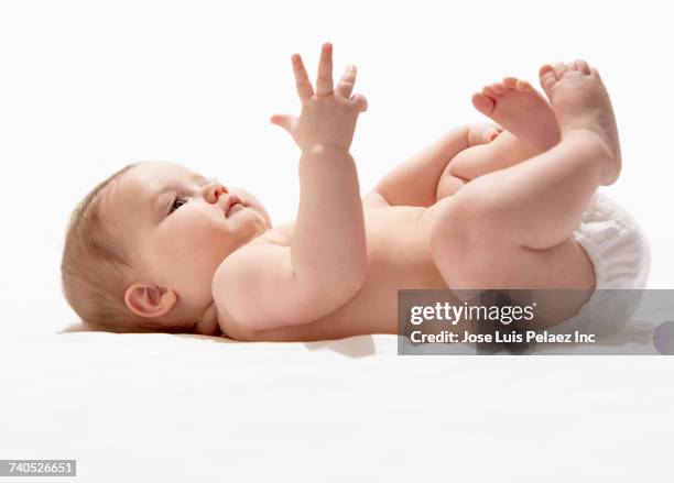 baby girl laying on floor wearing diaper - supino foto e immagini stock