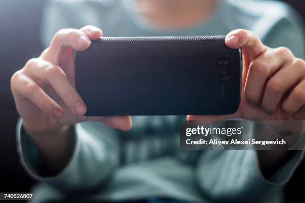 close up of caucasian boy photographing with cell phone - photo messaging foto e immagini stock