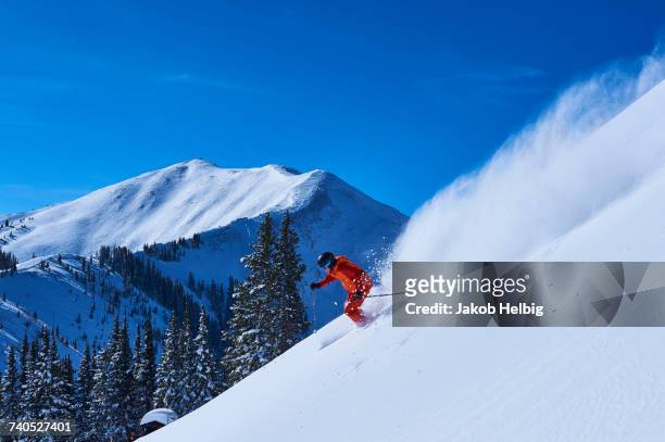 man skiing down steep snow covered mountainside, aspen, colorado, usa - アスペン ストックフォトと画像