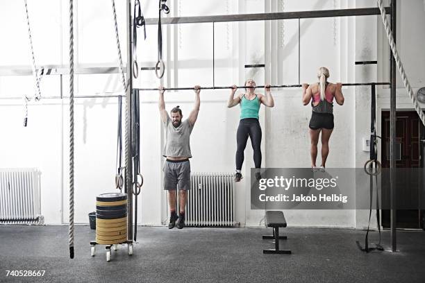 friends doing chin-up in cross training gym - chin ups stock pictures, royalty-free photos & images