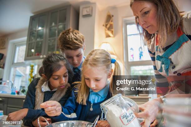 childminder and children baking - baby sitting stock pictures, royalty-free photos & images