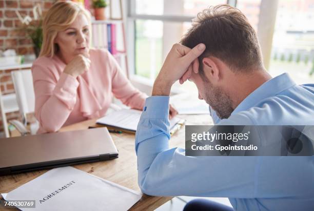 manager in office reprimanding employee with head in hands - annoying coworker stock pictures, royalty-free photos & images
