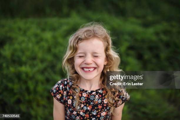 portrait of girl with wavy blond hair and missing tooth in field - blond hair girl fotografías e imágenes de stock