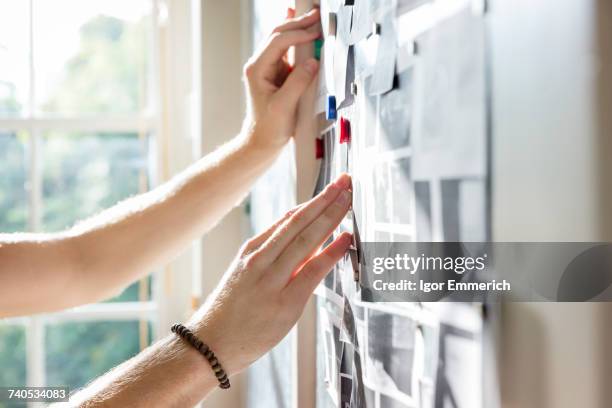 hands of male designer pinning mood board ideas to wall in creative studio - 設計室 個照片及圖片檔