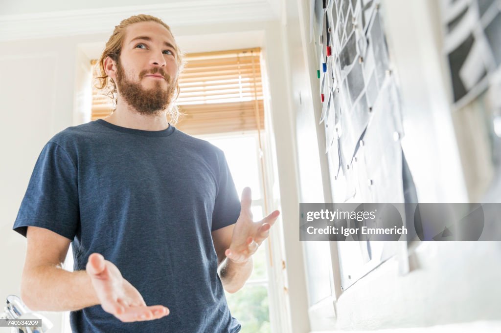 Young male designer explaining mood board idea in creative studio