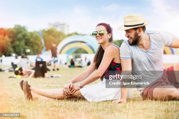 couple sitting on grass together at festival - day of the dead festival london stockfoto's en -beelden