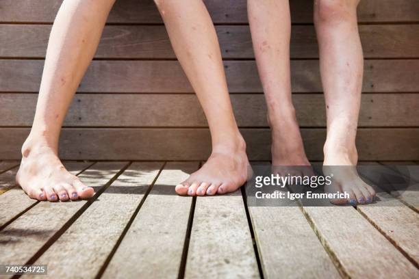 two girls standing barefoot, view of legs - tween heels stock pictures, royalty-free photos & images