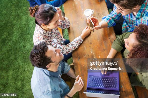 overhead view of digital designers at office table looking at smartphone - design studio woman chinese laptop stock pictures, royalty-free photos & images