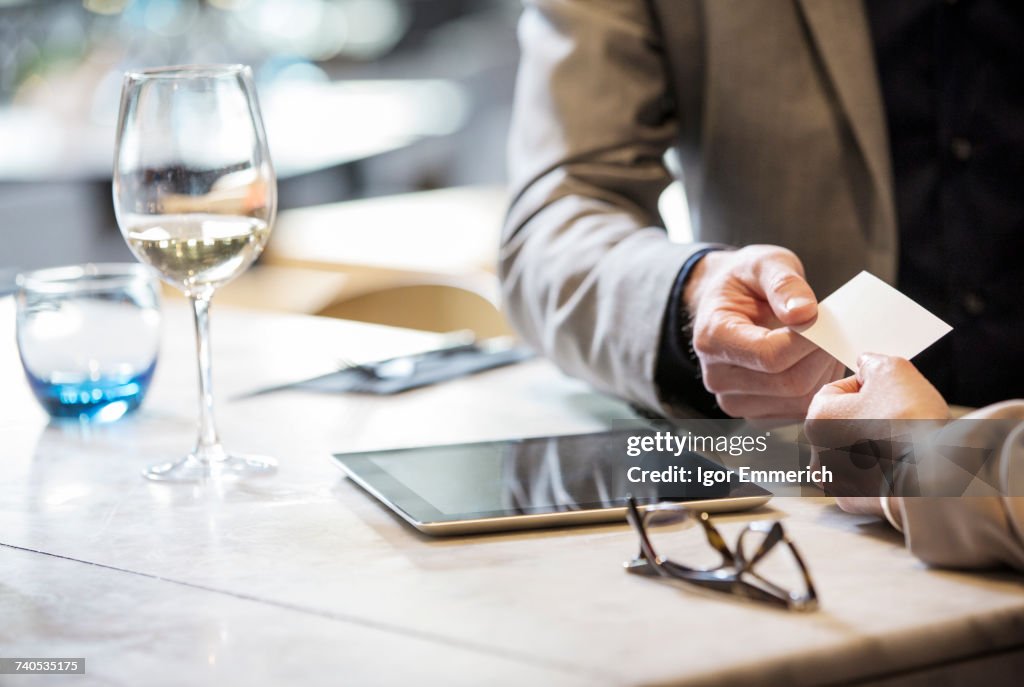 Businessman and businesswoman making introductions at lunch in restaurant