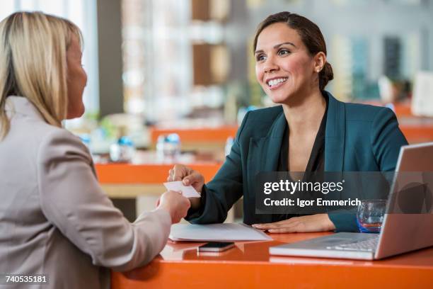 businesswomen making introductions in cafe - business card stock pictures, royalty-free photos & images