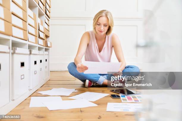 female designer sitting on floor creating mood board in creative studio - moodboard stock pictures, royalty-free photos & images