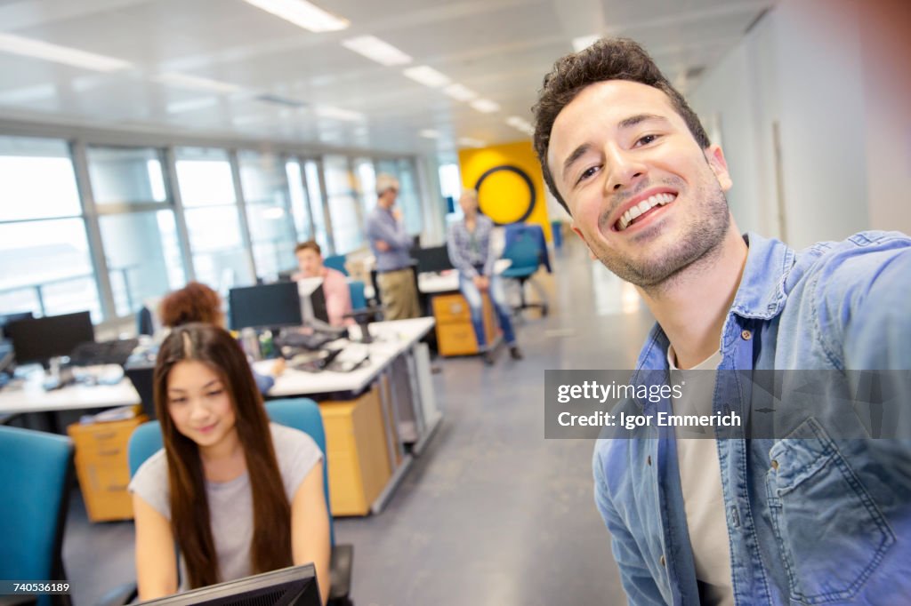 Male digital designer taking selfie in office