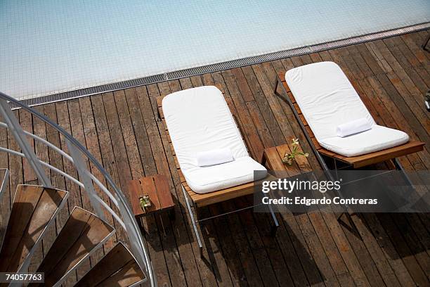 two sunloungers on deck beside swimming pool, elevated view - wood deck top view stock pictures, royalty-free photos & images