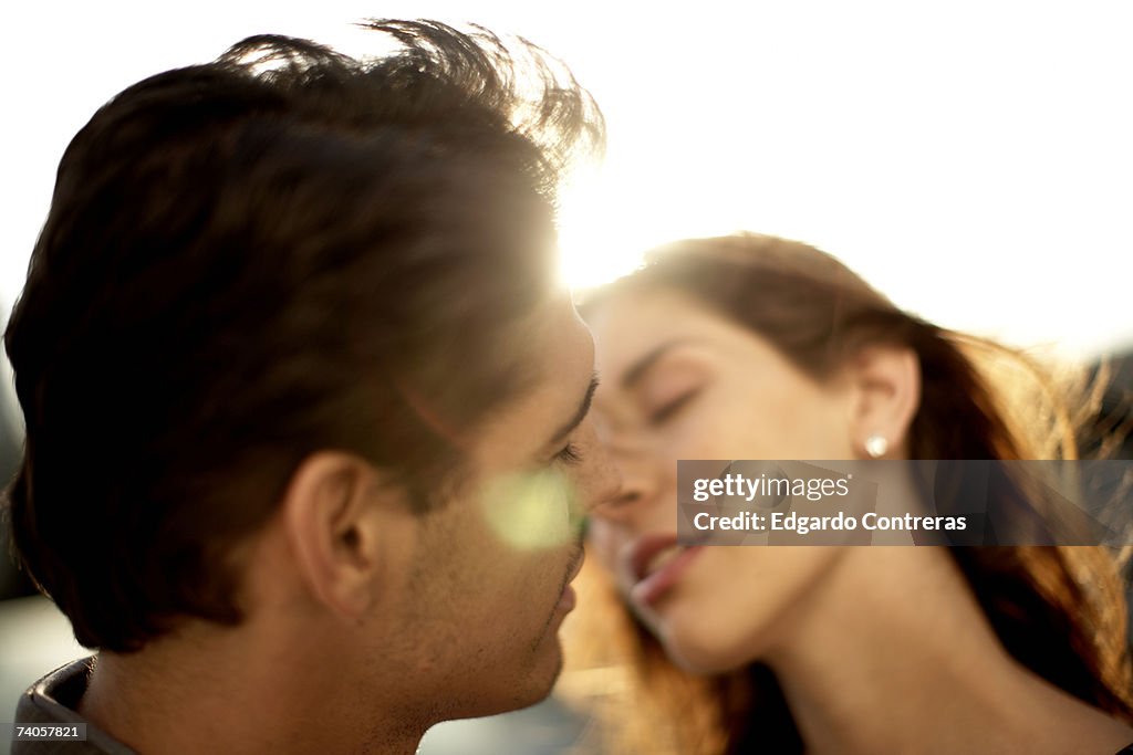 Young couple kissing, outdoors, close-up