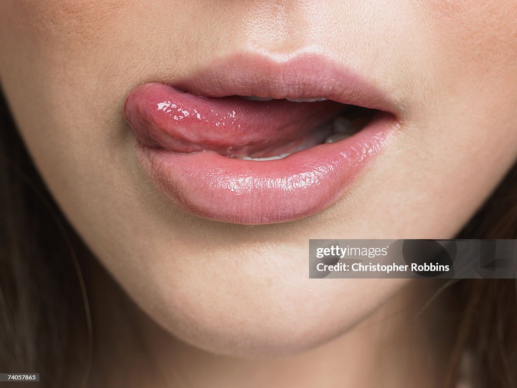 Young woman, licking lips, close-up of mouth