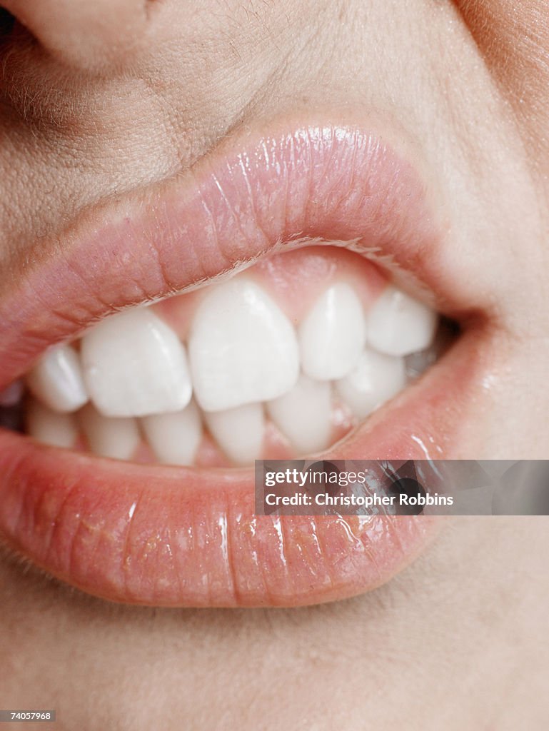 Young woman making a face, close-up of mouth